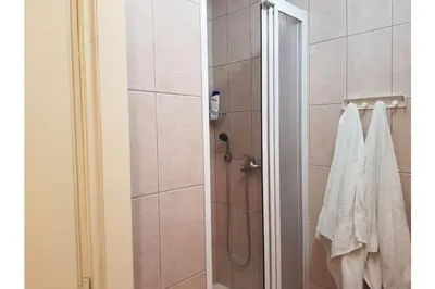 a bathroom with a shower with a white towel at Bella Centre Apartment in Belgrade