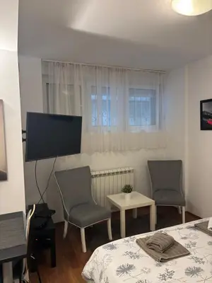 a living room with two chairs and a flat screen tv at Bella Centre Apartment in Belgrade