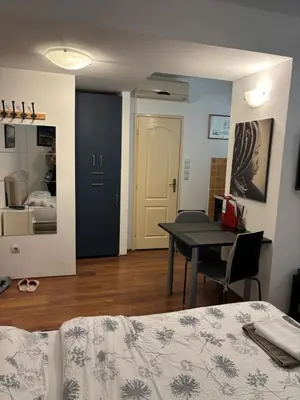 a room with a bed and a table and a bedroom at Bella Centre Apartment in Belgrade