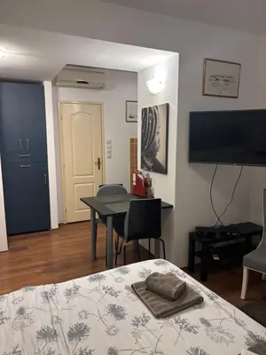 a room with a bed and a table and a tv at Bella Centre Apartment in Belgrade