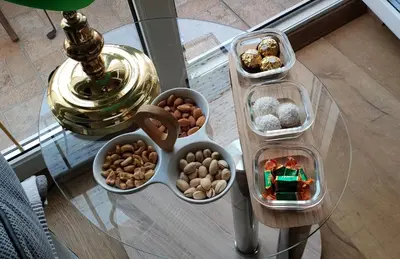 a glass table topped with bowls of cookies and nuts at Bella Vita Apartment in Belgrade
