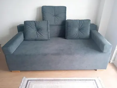 a blue couch with two pillows in a room at Bella Vita Apartment in Belgrade