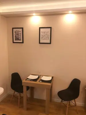 a table with two chairs and a picture on the wall at Apartment Maximus lux in Belgrade