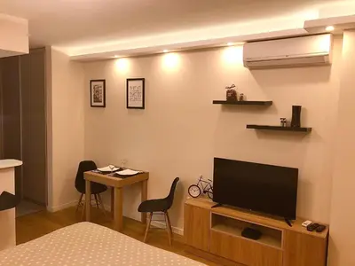 a room with a television and a table with chairs at Apartment Maximus lux in Belgrade