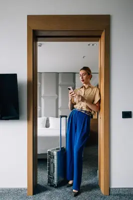 a woman looking at her cell phone in a hotel room at Hotel Mona Plaza in Belgrade