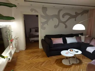 a living room with a black couch and a table at Apartment De Luna Belgrade in Belgrade