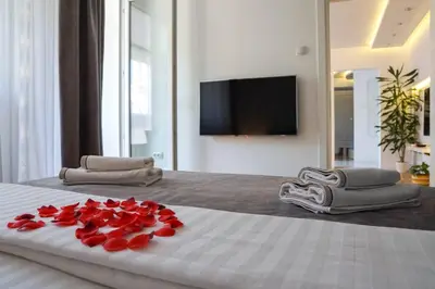 a bed with red roses on it with a television at Apartment De Luna Belgrade in Belgrade