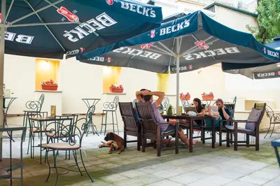 a group of people sitting at a table under an umbrella at Villa Bulevar in Belgrade