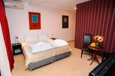 a bedroom with a bed with white pillows on it at Villa Bulevar in Belgrade