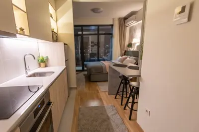 a kitchen with a sink and a living room at Belgrade Waterfront GREEN Apartment in Belgrade