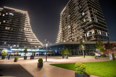 a large building with two tall buildings at night at Belgrade Waterfront GREEN Apartment in Belgrade
