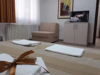 a living room with a chair and a table with towels at Apartman Karadjordje in Zvezdara