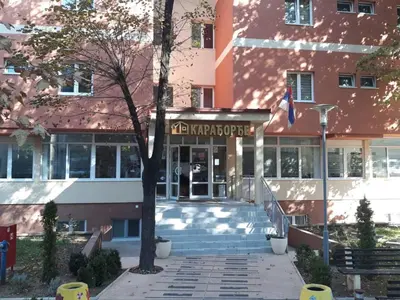 a school building with a flag in front of it at Apartman Karadjordje in Zvezdara