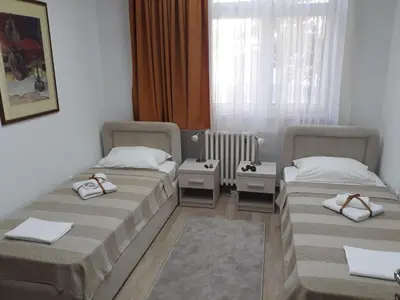 a room with two beds and a window at Apartman Karadjordje in Zvezdara