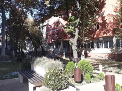 a park with a bench in front of a building at Apartman Karadjordje in Zvezdara