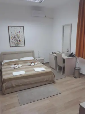 a bedroom with a bed and a desk and a table at Apartman Karadjordje in Zvezdara