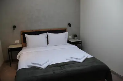 a bedroom with a large bed with two towels on it at Urban Lodge Belgrade in Belgrade