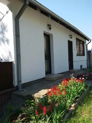 a white building with red flowers in front of it at Apartman Sissi in Pančevo