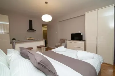 a bedroom with two white beds and a television at Vracar Vuk 2 in Belgrade