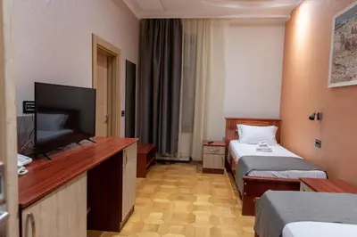 a hotel room with two beds and a flat screen tv at Hotel Kutko in Pančevo