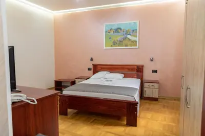 a bedroom with a bed and a television in it at Hotel Kutko in Pančevo