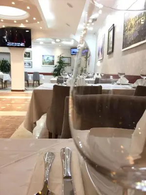 a dining room with a table with a wine glass at Hotel Kutko in Pančevo