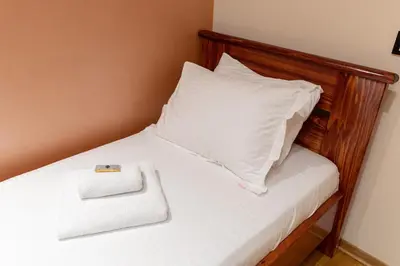 a bed with a wooden headboard and a white pillow at Hotel Kutko in Pančevo
