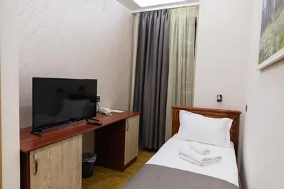 a hotel room with a bed and a flat screen tv at Hotel Kutko in Pančevo