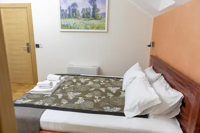a small bedroom with a bed with a blanket at Hotel Kutko in Pančevo
