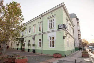 a green and white building on a city street at Hotel Kutko in Pančevo