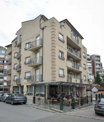 a tall building with people sitting outside of it at Park Srce Apartments in Arandjelovac