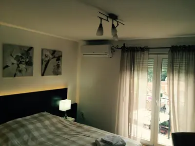 a bedroom with a bed and a window with a view at Park Srce Apartments in Arandjelovac