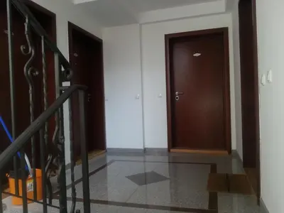 a hallway with two brown doors and a staircase at Park Srce Apartments in Arandjelovac