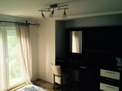 a bedroom with a bed and a chair and a window at Park Srce Apartments in Arandjelovac