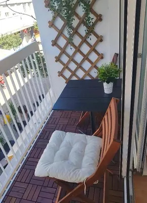 a chair with a pillow on a table on a balcony at Apartman Harmony in Smederevo