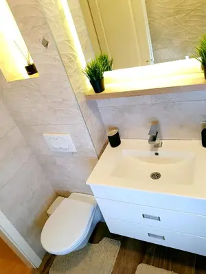 a bathroom with a white sink and a toilet at Apartman Harmony in Smederevo