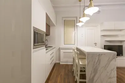a kitchen with white cabinets and a counter top at Belgrade Center Apartment Slavija Square II in Belgrade