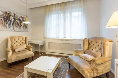 a living room with two chairs and a table at Belgrade Center Apartment Slavija Square II in Belgrade