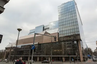 a large glass building with a traffic light in front of it at Belgrade Center Apartment Slavija Square II in Belgrade