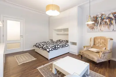 a bedroom with a bed and a chair and a table at Belgrade Center Apartment Slavija Square II in Belgrade