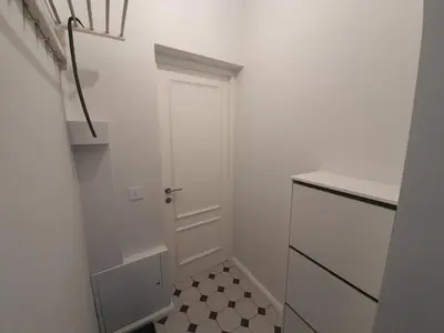 a hallway with a white door and a tiled floor at Belgrade Center Apartment Slavija Square III in Belgrade