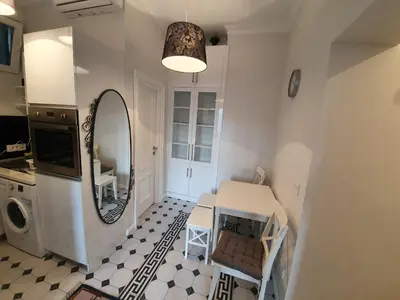 a small kitchen with a table and a mirror at Belgrade Center Apartment Slavija Square III in Belgrade