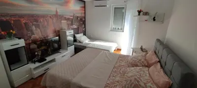 a bedroom with a bed and a large tv at White Night City Center Apartman in Belgrade