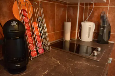 a kitchen counter with a coffee maker and utensils at White Night City Center Apartman in Belgrade