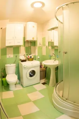 a bathroom with a toilet a sink and a washing machine at White Night City Center Apartman in Belgrade