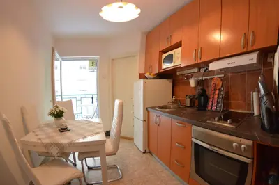 a small kitchen with a table and a refrigerator at White Night City Center Apartman in Belgrade