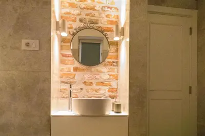 a bathroom with a sink and a mirror on a wall at Twin Center Apartments in Belgrade