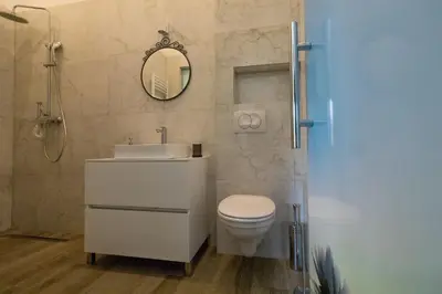 a bathroom with a toilet and a sink and a mirror at Twin Center Apartments in Belgrade