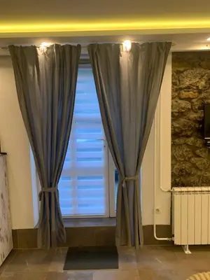 a window with blue curtains in a room at Apartman Nina BANOVO BRDO in Belgrade
