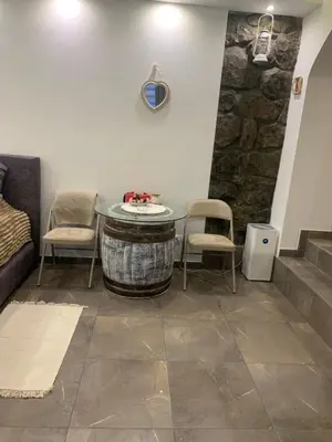 a room with a table and chairs and a stone wall at Apartman Nina BANOVO BRDO in Belgrade